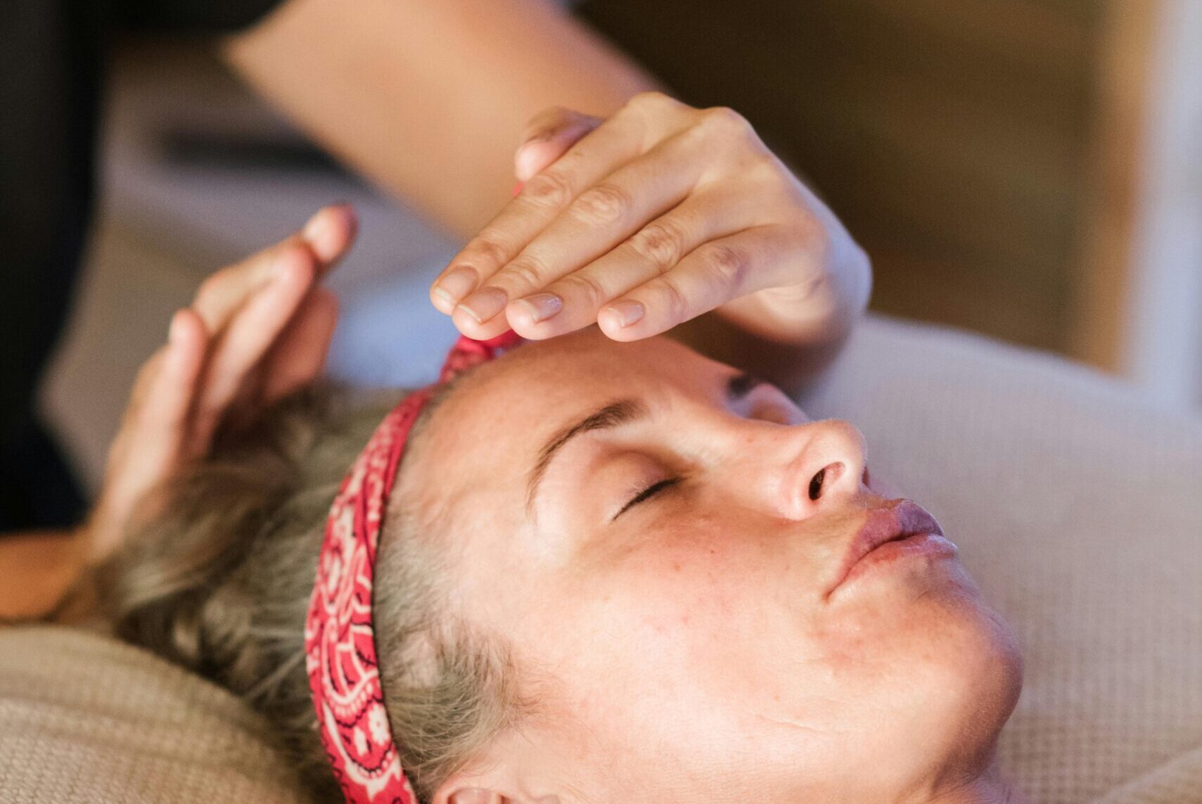 A woman enjoying a peaceful reiki session in a cozy spa setting for ultimate relaxation.